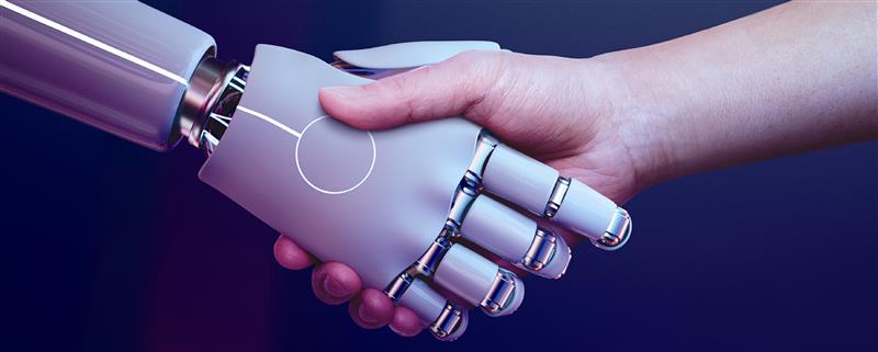 Human hand shaking hands with a robotic hand, symbolizing AI-human collaboration.