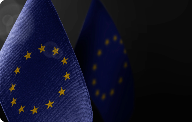 A close-up of the European Union flag, with its characteristic blue background and a circle of twelve yellow stars.