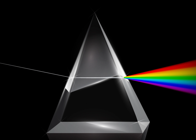 A triangular prism disperses white light into a rainbow spectrum.